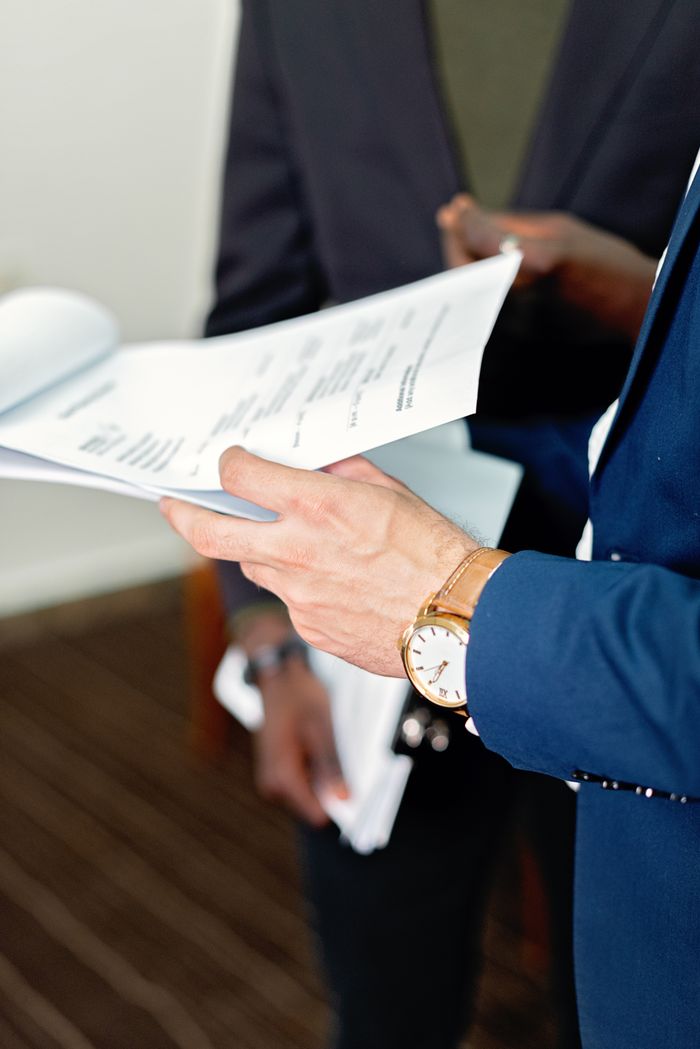 The Art of Drawing Readers In: Your attractive post title goes here Close-up of professionals reviewing documents in a meeting, focusing on details and teamwork.